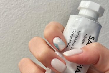 Маникюр на короткие ногти в пастельно-молочной гамме с клетчатым принтом на одном пальце