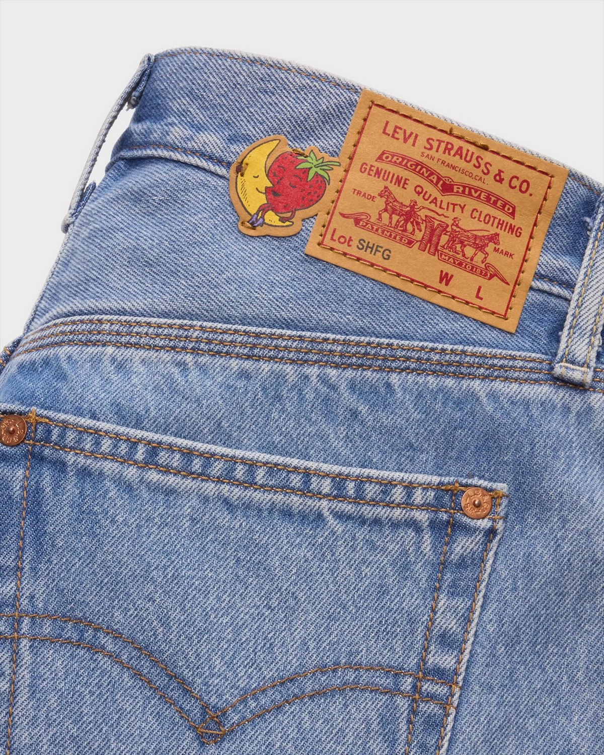 Крупный план заднего кармана джинсов Levi’s с совместным ярлыком и нашивкой в виде клубники и луны