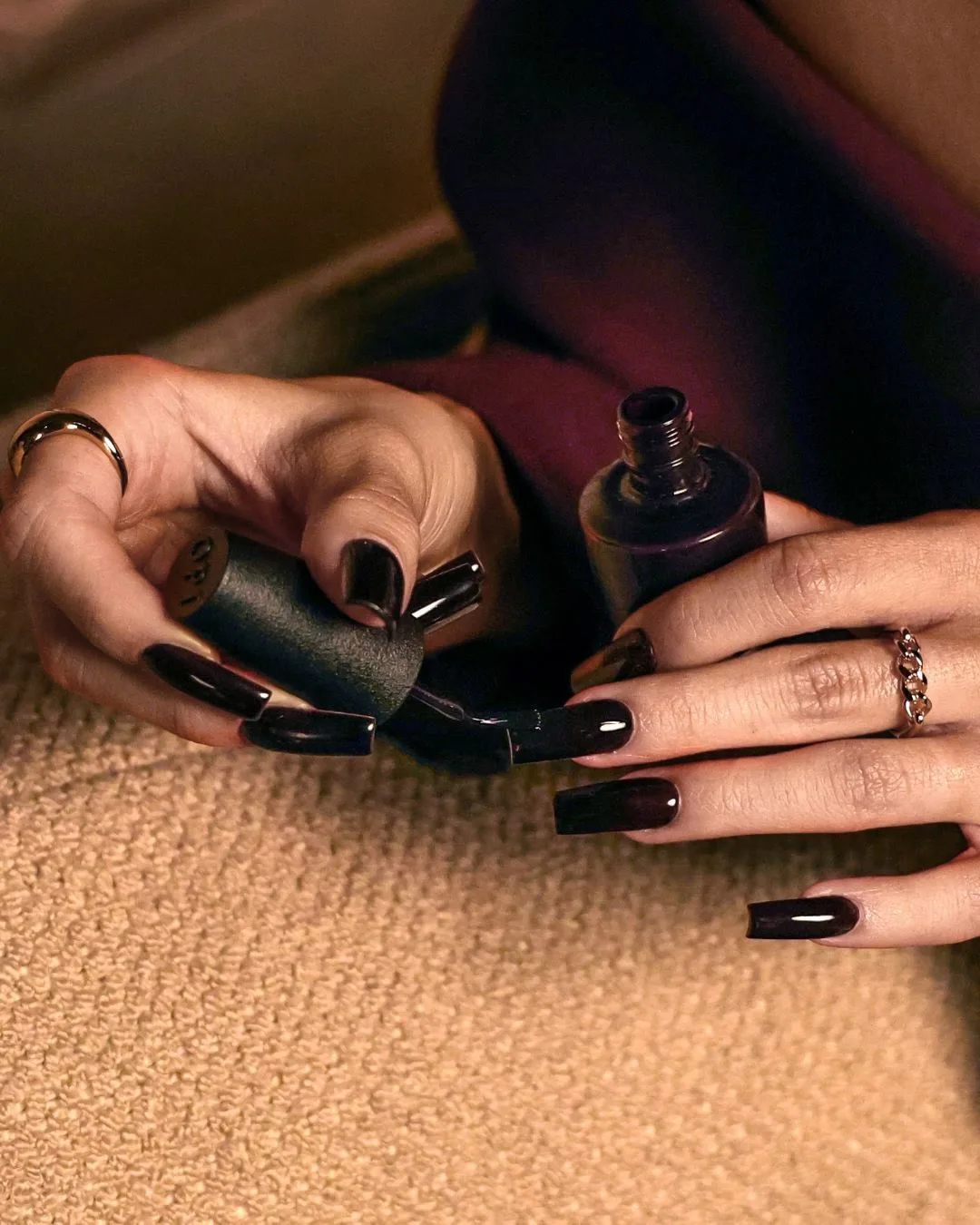 Длинные ногти с темно-фиолетовым лаком и флакон OPI